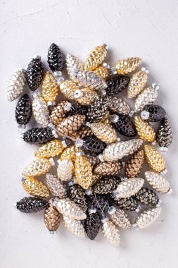 Noel süsleriyle yatıyordu. Gri desenli arka planda cam altın, siyah, gümüş renkli dekoratif koniler. İskandinav minimalist tarzı. Durgun hayat. Üst görünüm.