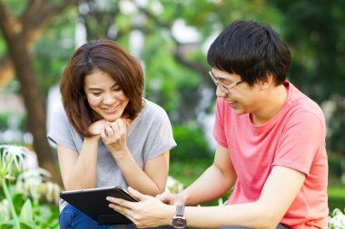 bir tablet oynayan gençler