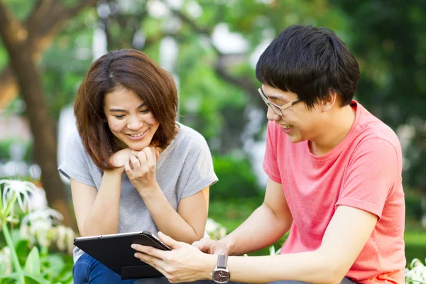 bir tablet oynayan gençler