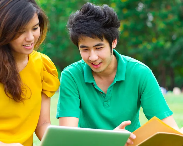 Estudiantes leyendo un libro juntos — Foto de Stock