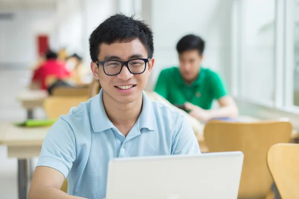 Student na přenosném počítači v knihovně. — Stock fotografie