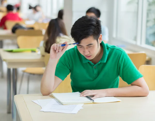 Aziatische student werkt in de bibliotheek. — Stockfoto