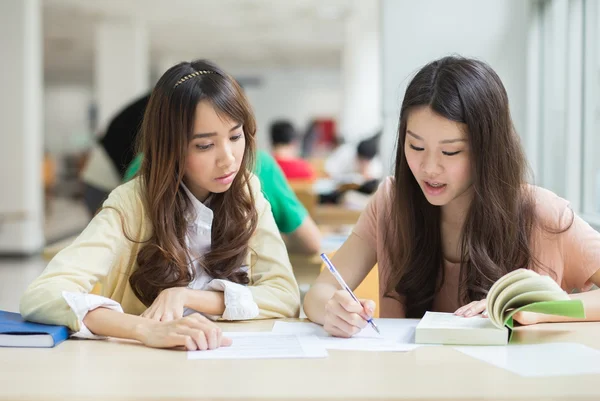 Aziatische studenten werken in de bibliotheek. — Stockfoto