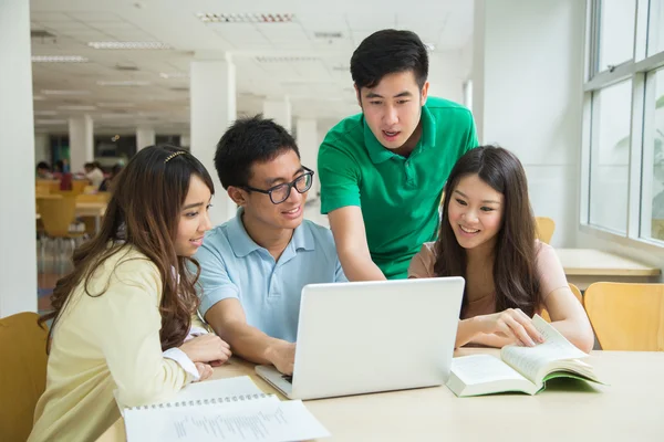 Aziatische studenten werken in de bibliotheek. — Stockfoto