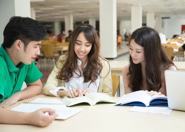 Asiatische Studenten arbeiten in der Bibliothek Stockbild