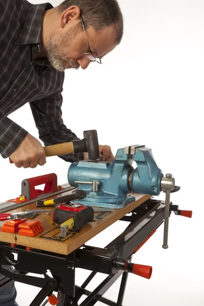 The man with a hammer in a joiner's workshop. — Stock Photo, Image