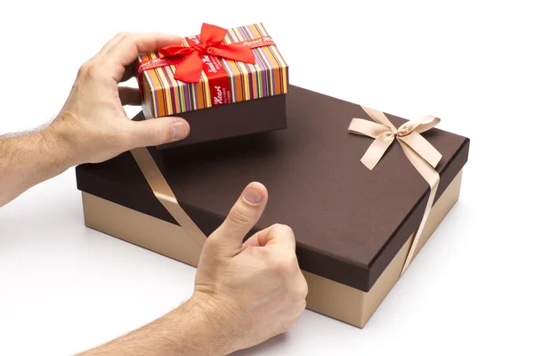 Geschenk dozen en met de hand met een vinger omhoog. — Stockfoto