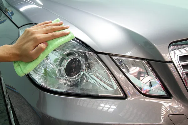 Mão com uma microfibra de esfregão o polimento de carro — Fotografia de Stock