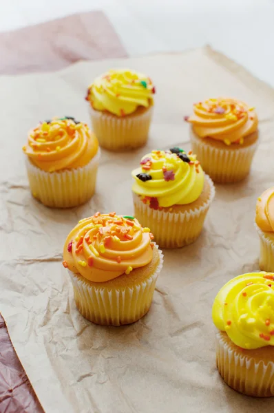Gele en oranje cupcakes met suikerglazuur — Stockfoto