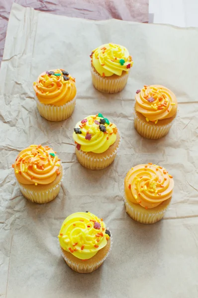 Cupcakes top view with orange and yellow frosting — Stock Photo, Image