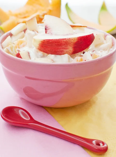 Bol de salade de fruits avec cuillère rouge — Photo