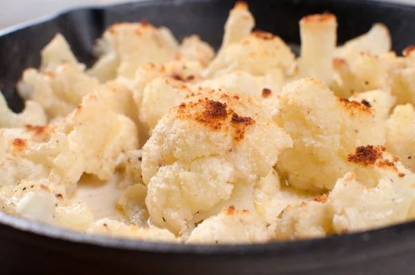 Closeup cauliflower baked florets in cast iron pan — Stock Photo, Image