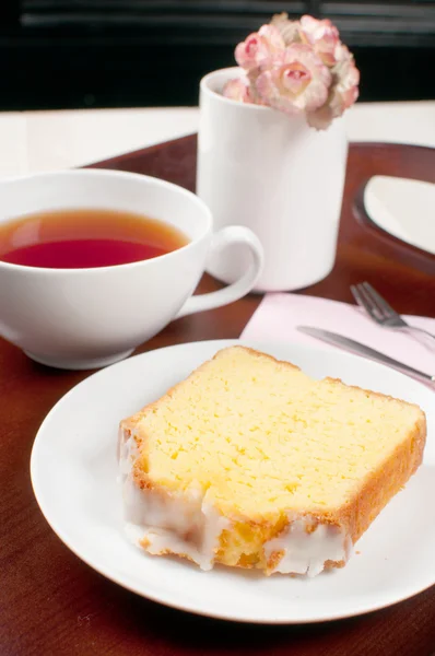 Kahvaltı tepsisiyle çay, limonlu somun ve çiçekler — Stok fotoğraf