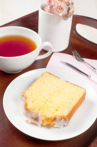 Fatia de bolo de esponja de limão com chá — Fotografia de Stock