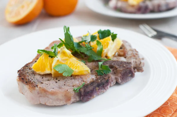 Pork bone-in chops with oranges and herbs — Stock Photo, Image