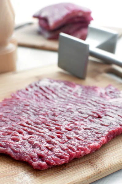 Raw beef round steak and pounder — Stock Photo, Image