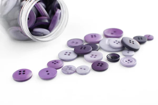 Tombol ungu tumpah dari toples — Stok Foto