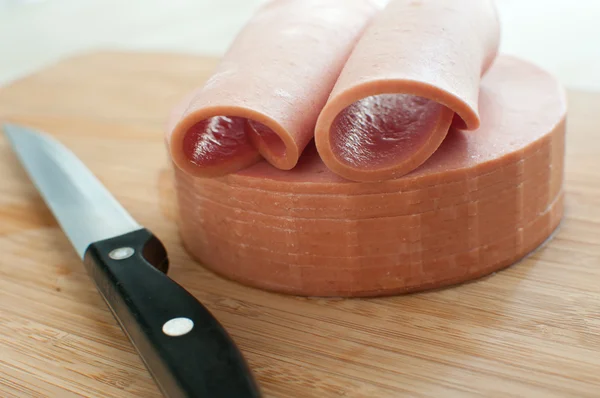 Sliced bologna sausage on cutting board — Stock Photo, Image