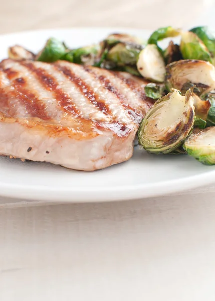 Grilled pork chop with brussels sprouts — Stock Photo, Image