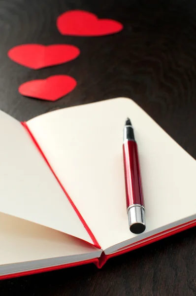 Cuaderno con pluma roja y corazones Fotos de stock