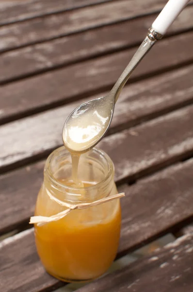 Mettre une cuillère dans du miel liquide — Photo