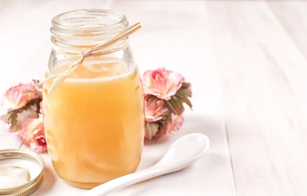 Frasco de mel aberto com tampa e colher — Fotografia de Stock