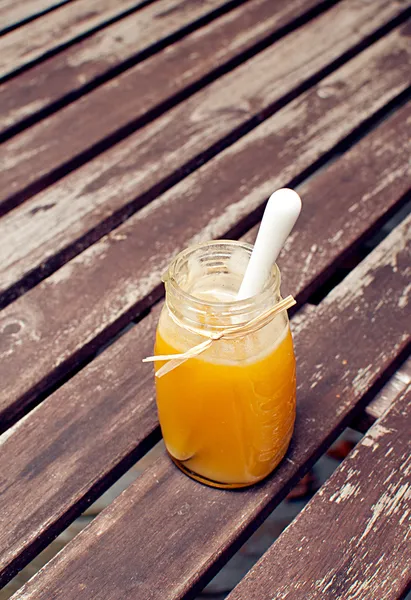 Spoon sticking in glass jar with honey — Stock Photo, Image