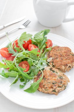 Balık köftesi maydanoz, roka, domates salatası ile