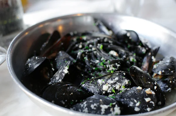 Mussels with garlic sauce and black pasta — Stock Photo, Image