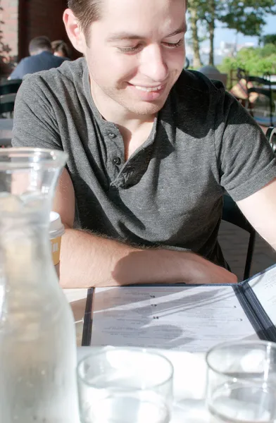 Smiling man reading menu in restaurant Stock Picture