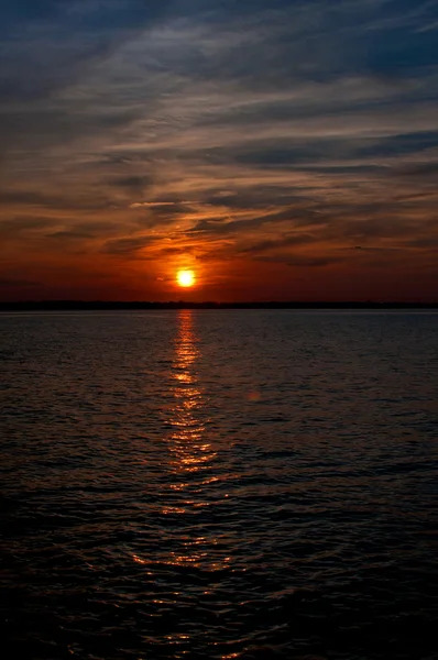 Dramatischer orangefarbener Sonnenuntergang am dunklen Himmel mit Wolken Stockbild