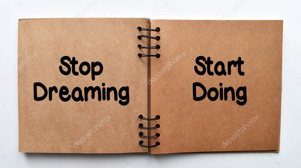 Stop dreaming, start doing, motivating quotation phrase. Inspirational motivating quote on notebook paper.