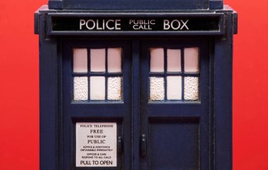 Polis telefon kulübesi kırmızı arkaplanda izole edilmiş. Doctor Who 'dan TARDIS. Yakın plan.
