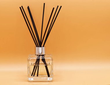 Oda spreyi bej arka planda izole edilmiş. Aroma çubukları ve gevşemek için gerekli yağ şişesi.