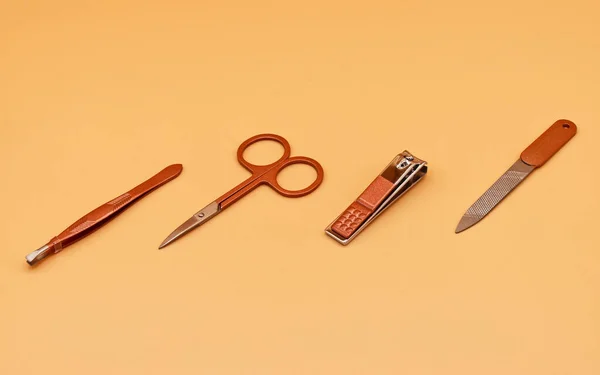 爪を切るためのセット ベージュ地にセットされたマニキュアのツール — ストック写真