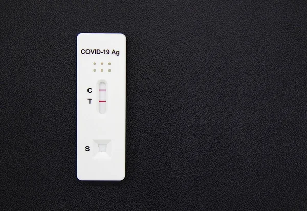 Positive test result of Covid-19 antigen test kit isolated on black background. Coronavirus protective concept