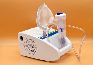 Tıbbi Nebulizer turuncu arka planda izole edildi. Nebulizer tedavisi terapi kavramı.