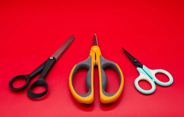 Different shape scissors isolated on red background