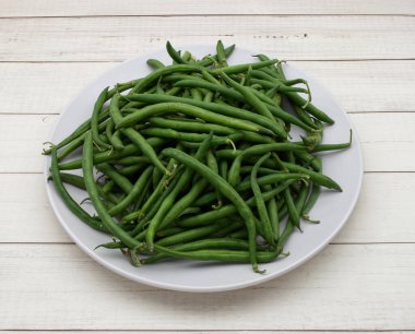 Raw green beans isolated on clear wooden background