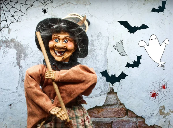 Halloween Witch doll in decorated dress holding a wooden broom. Trick or treat. Happy Halloween.