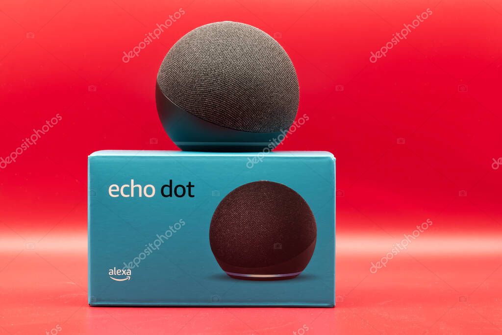 Bologna - Italy - September 14, 2022: Amazon Echo Dot. Alexa, virtual assistant AI. Red background