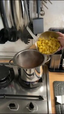İtalyan Tortellini makarnası suyun içinde kaynıyor. Dikey video 4K