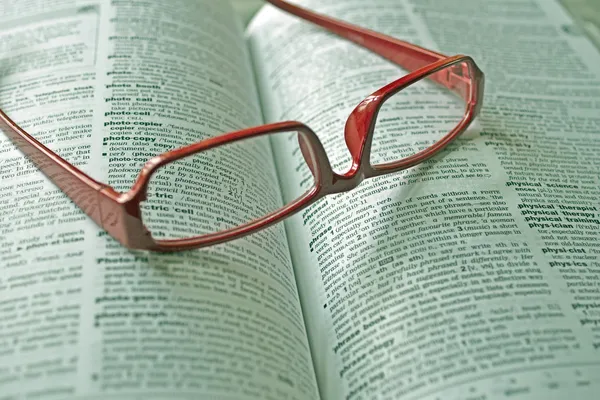 Словарь и очки для чтения — стоковое фото