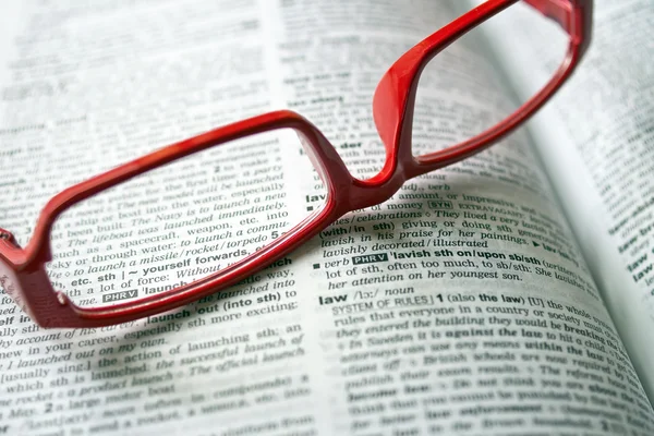 Dictionary and reading glasses — Stock Photo, Image