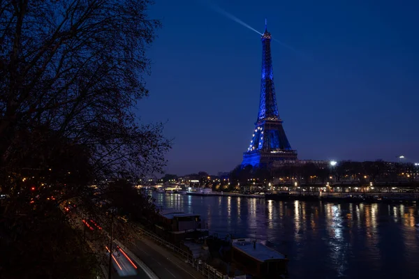 View along the Seine with Eiffel tower dressed in European flag lighting for the French presidency
