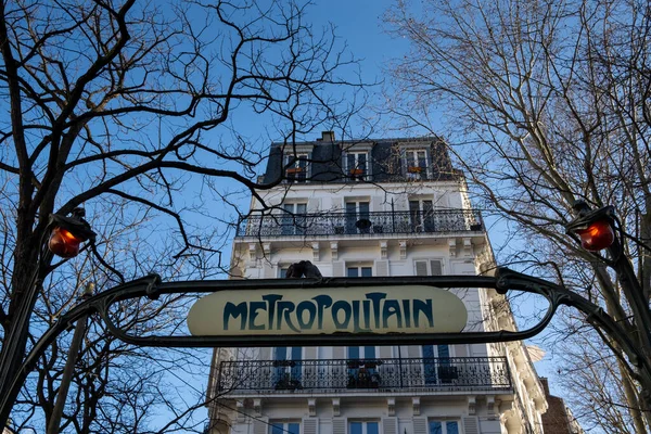 Paris metro kapısı, güvercinler ve klasik cepheli.