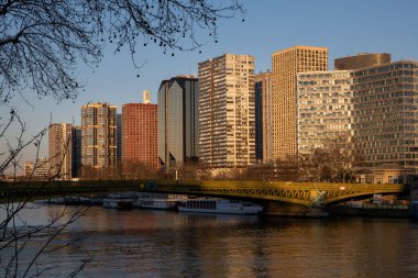 Paris 'teki Seine nehri boyunca akşam renkleriyle hizalanmış gökdelenlerin manzarası