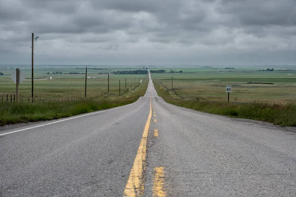 Straight road in the vast plains of Alberta in Canada