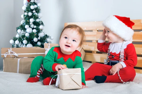 Crianças vestidas de Papai Noel e Elfos com presentes de Natal. Bebê em ternos de Ano Novo.. — Fotografia de Stock