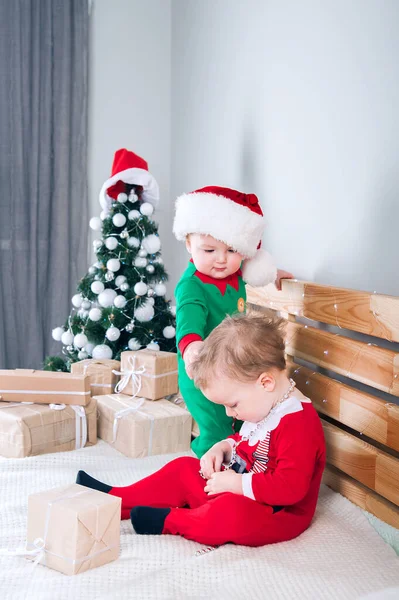 Crianças vestidas de Papai Noel e Elfos com presentes de Natal. Bebê em ternos de Ano Novo.. — Fotografia de Stock